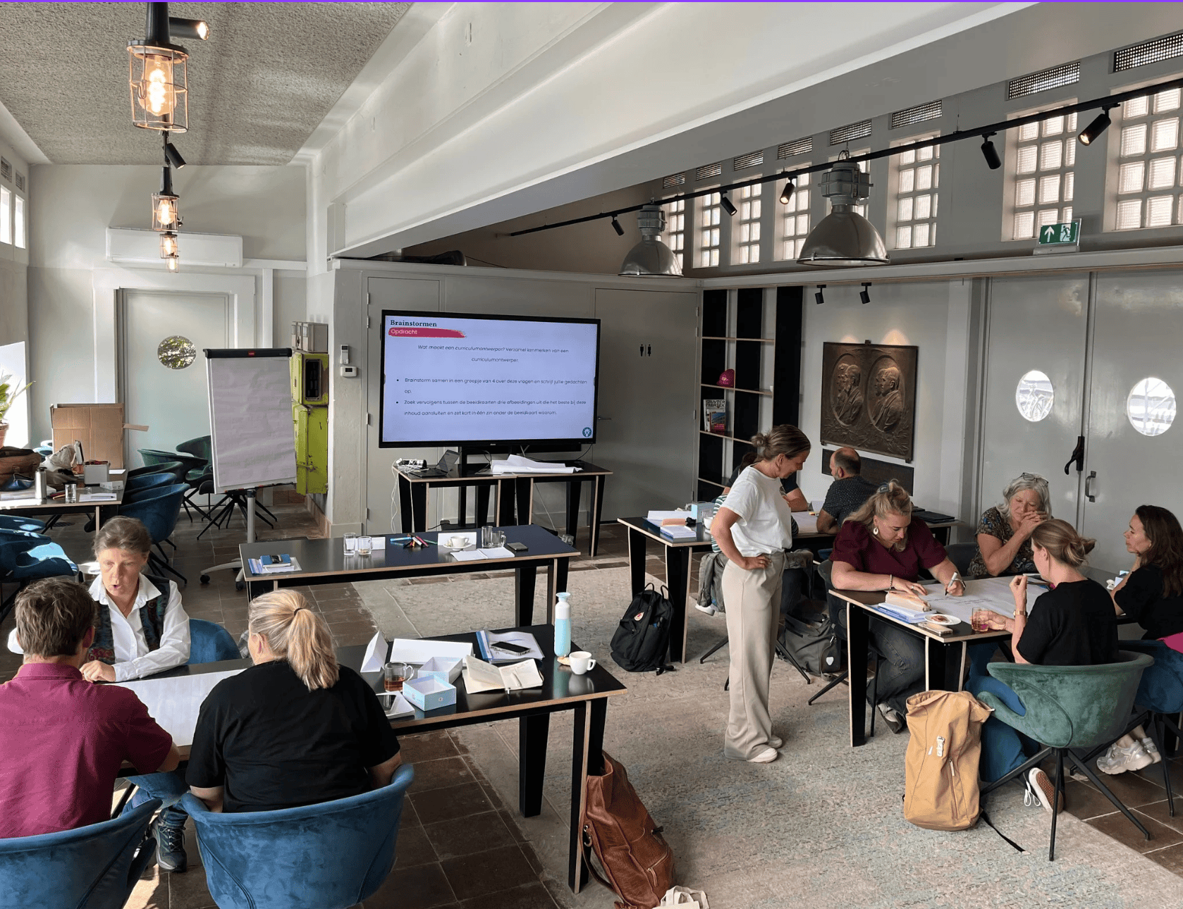 Deelnemers aan de opleiding werken in kleine groepen aan hun curriculum